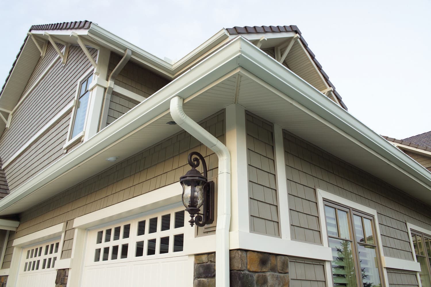 Craftsman home exterior with shake siding, seamless gutters, and stone accents