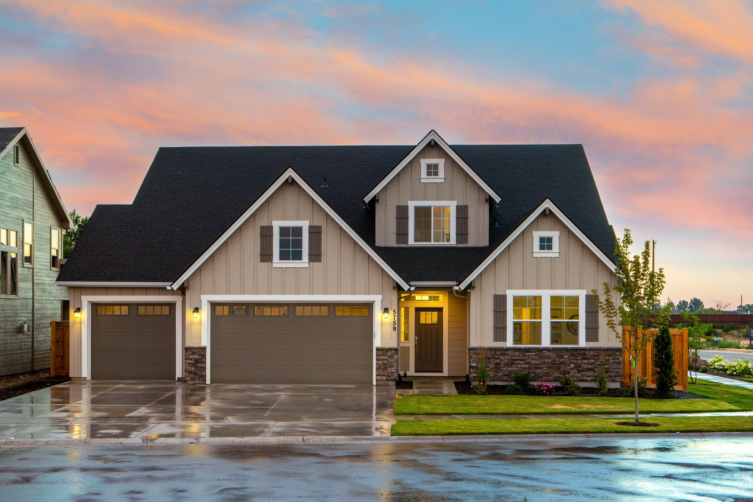 Modern craftsman two-story home with new dark shingle roof at sunset