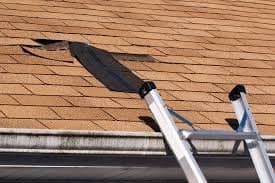 Wind damage with missing shingles on a roof in Ohio